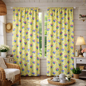 Floral patterned yellow curtains in a room with a chair, lamp, and decor items.